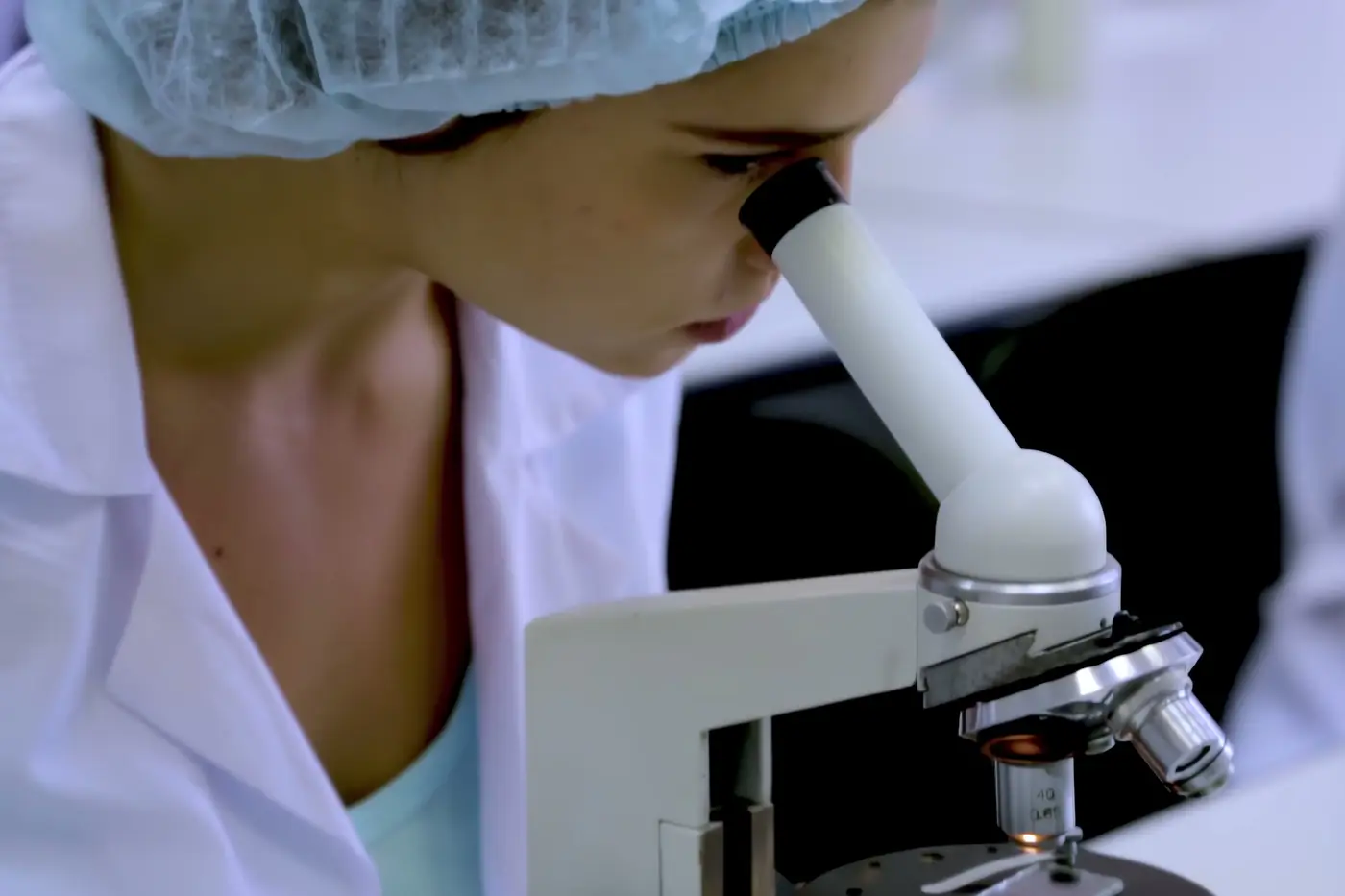 Laboratuvarda mikroskopla numune inceleyen araştırmacı